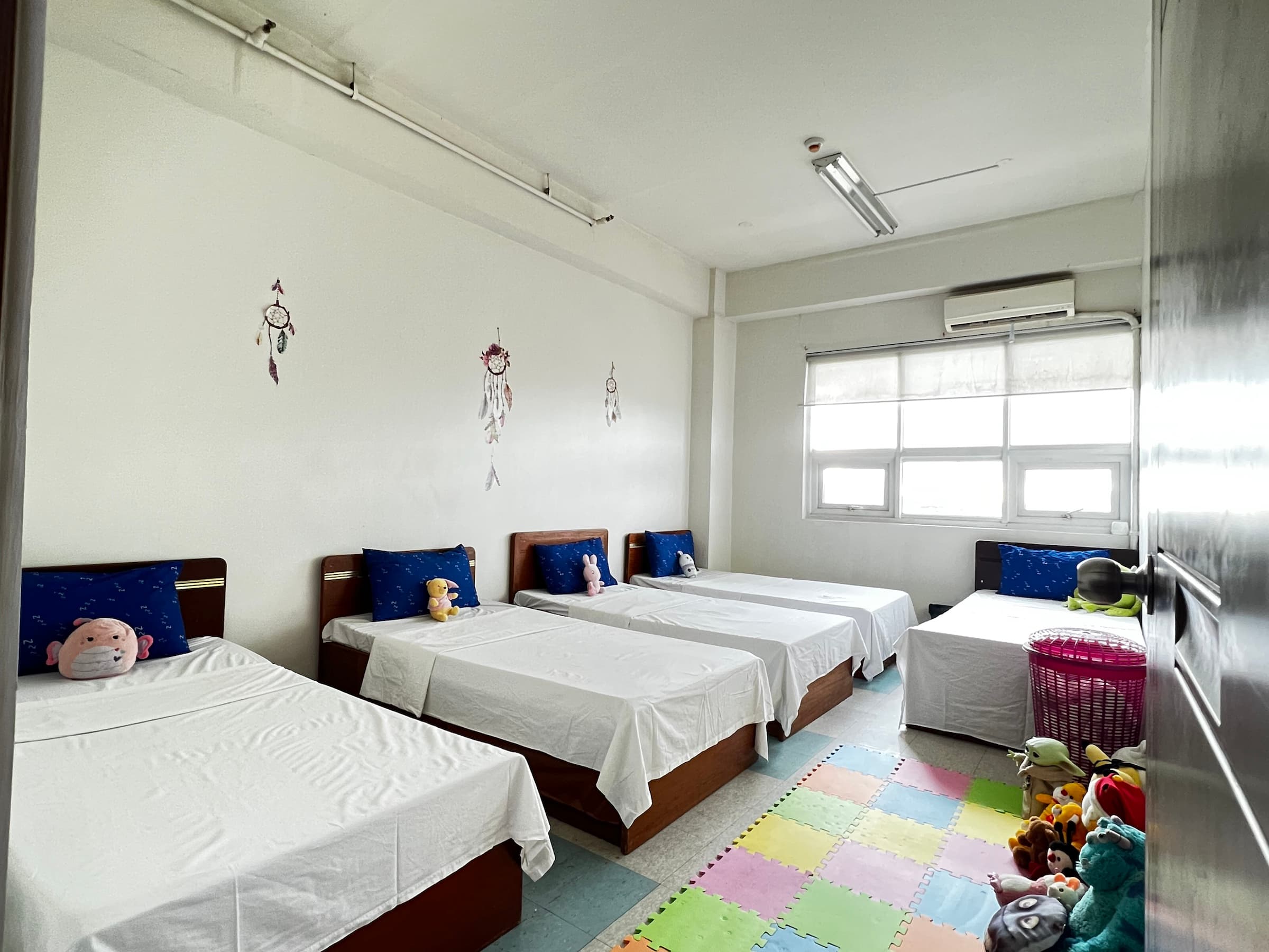 A children’s sleeping room with several prepared beds