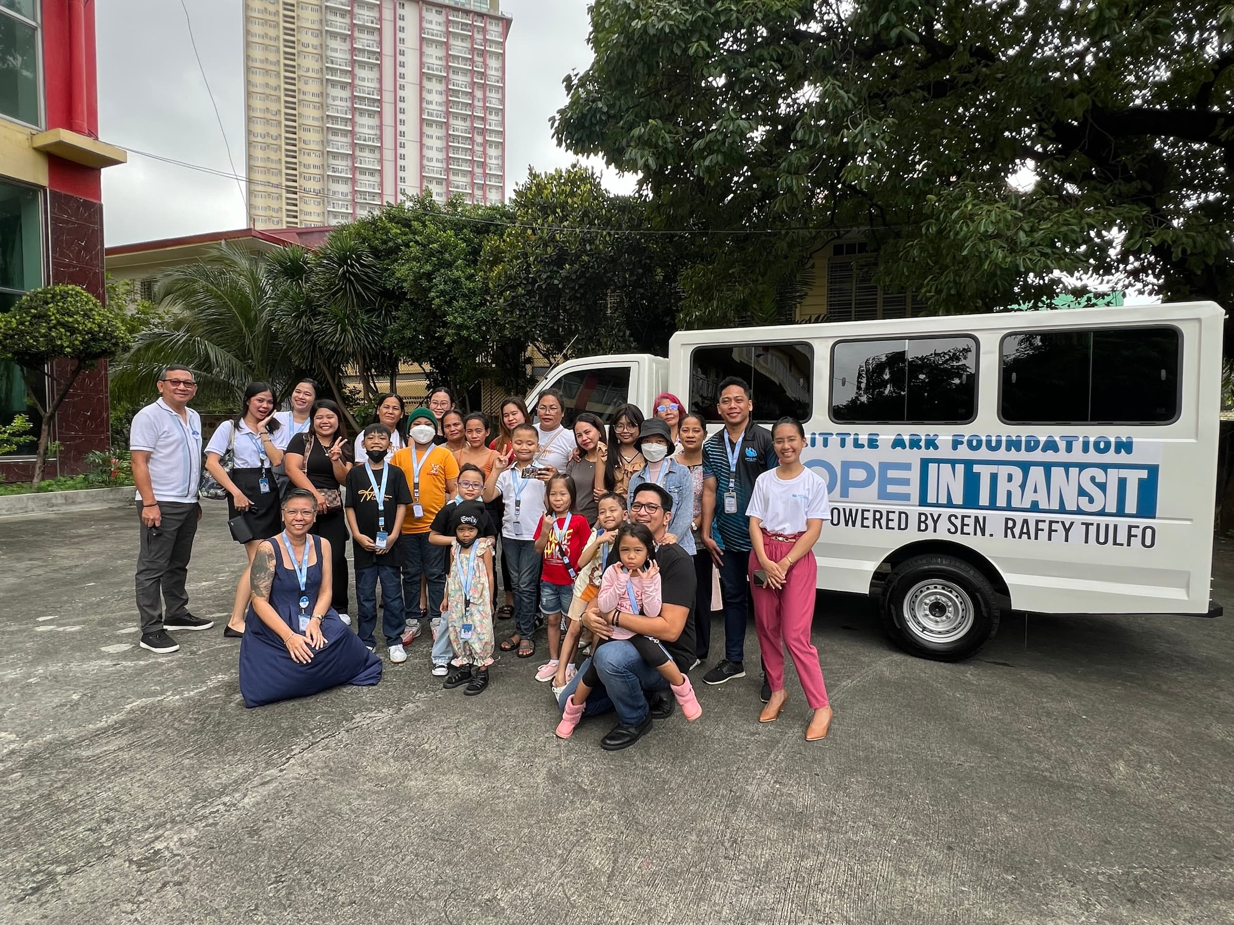 Children, families, and Little Ark Foundation supporters gathered beside the Hope in Transit vehicle