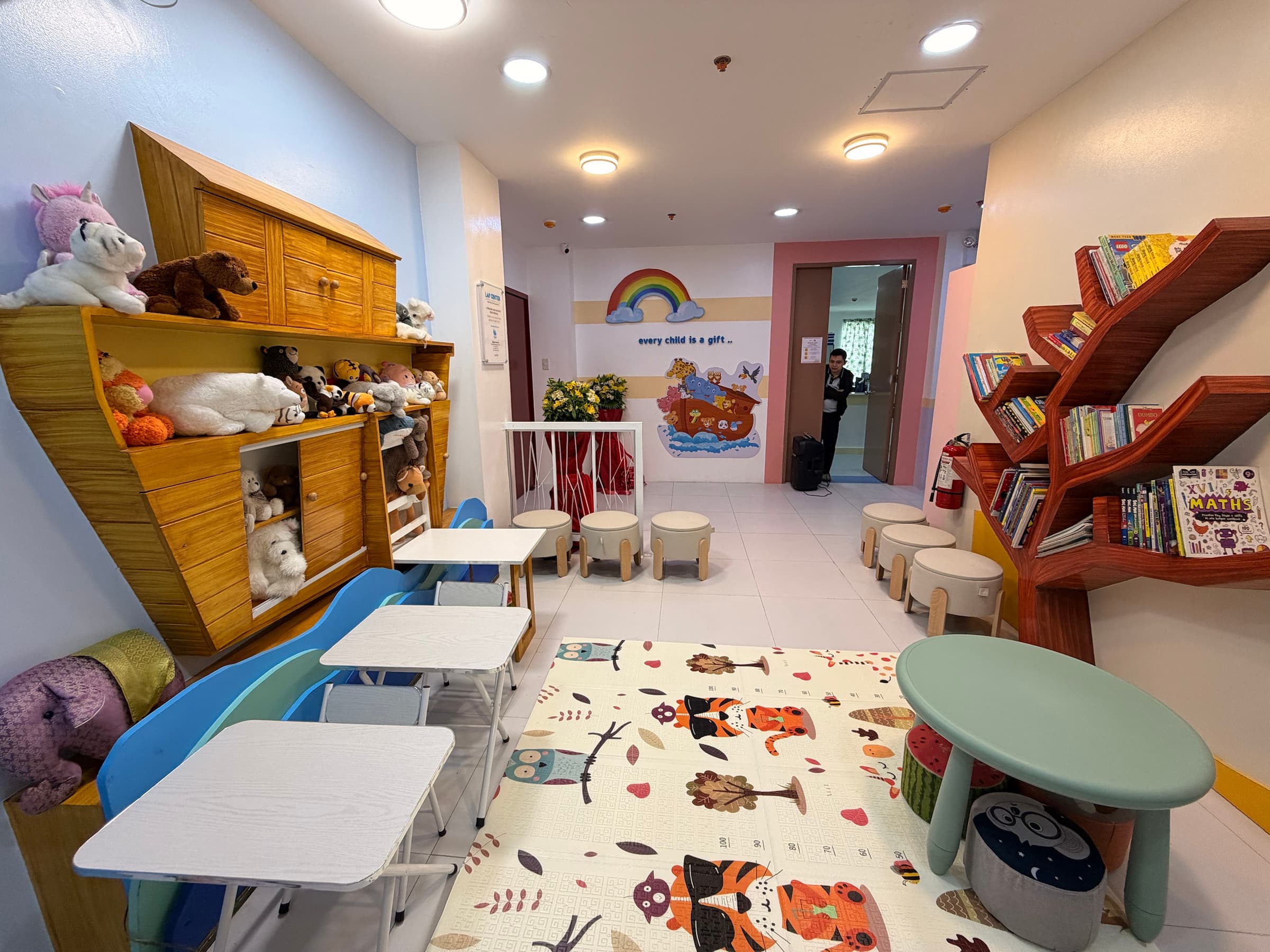 The LAF Center activity space with books, toys, tables, and an ark mural