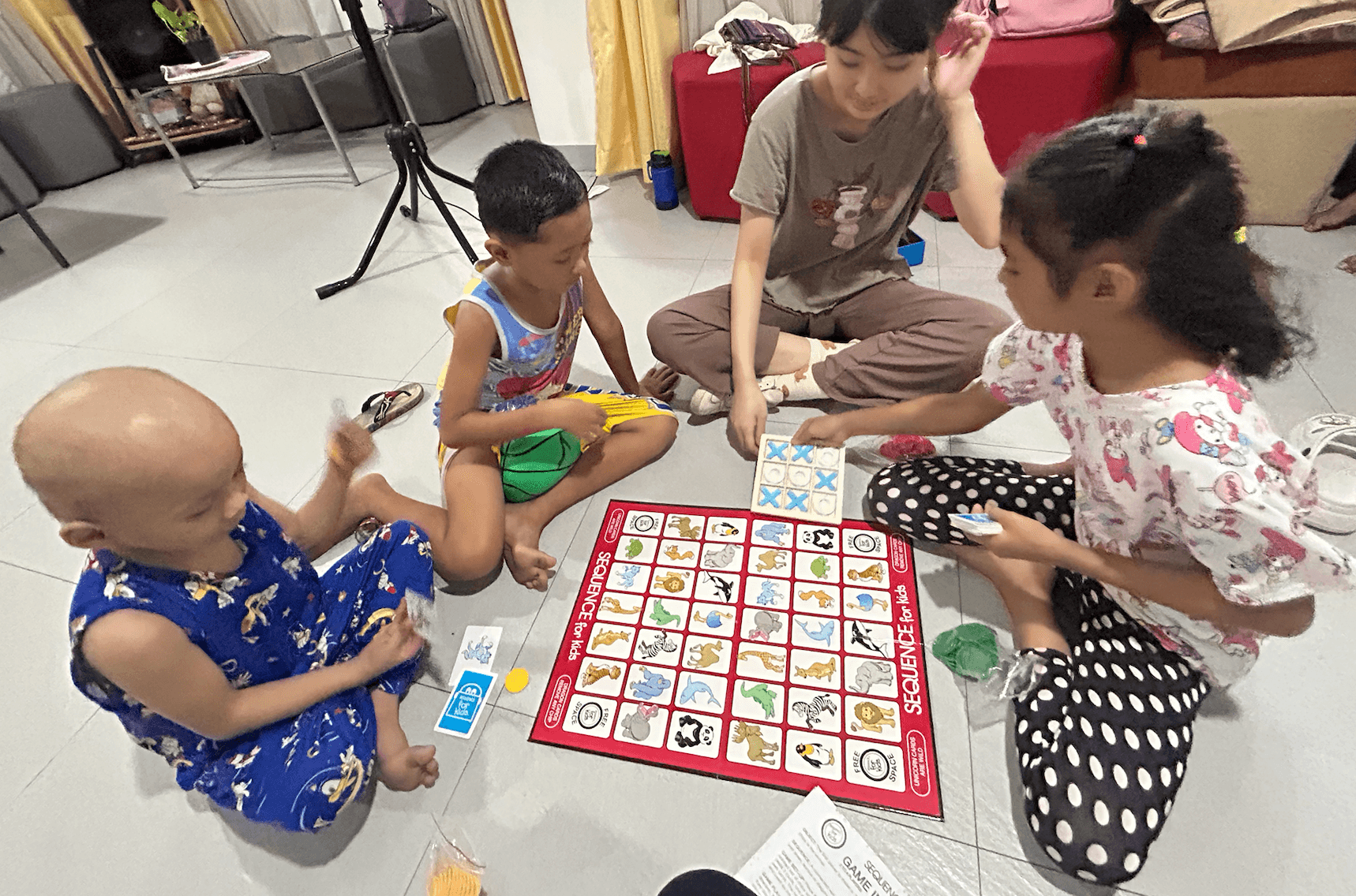 Children playing a board game with a Little Ark team member