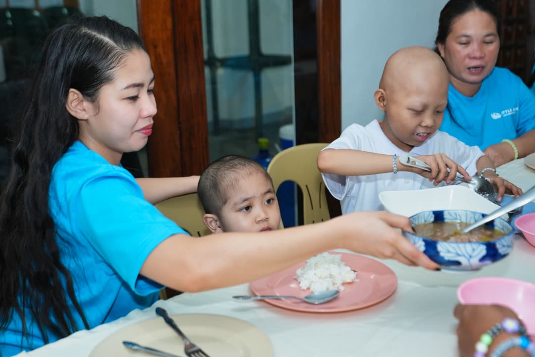 A Little Ark volunteer serving a warm meal to children and caregivers