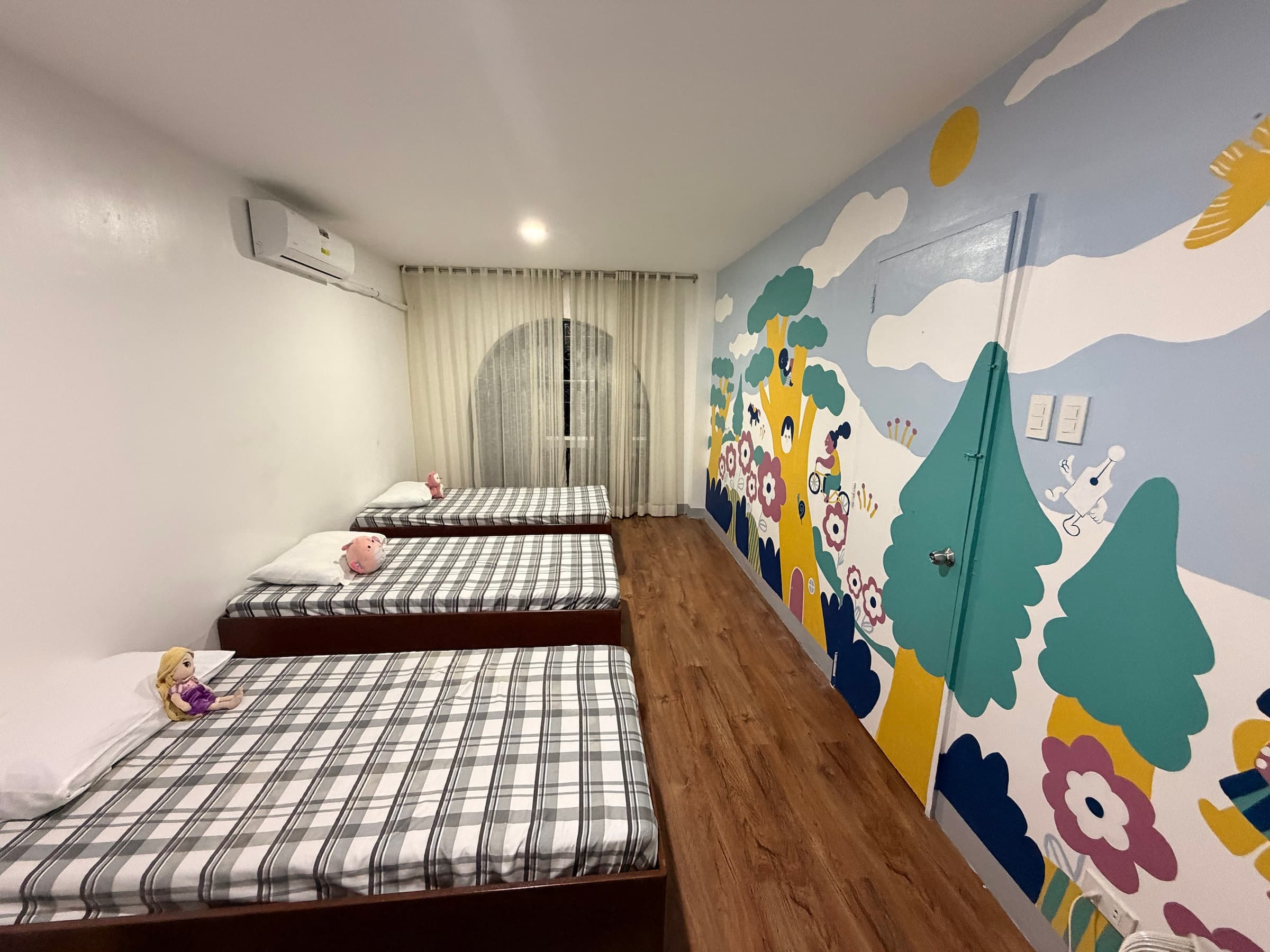 A shared bedroom with beds and a nature mural inside the Little Ark home