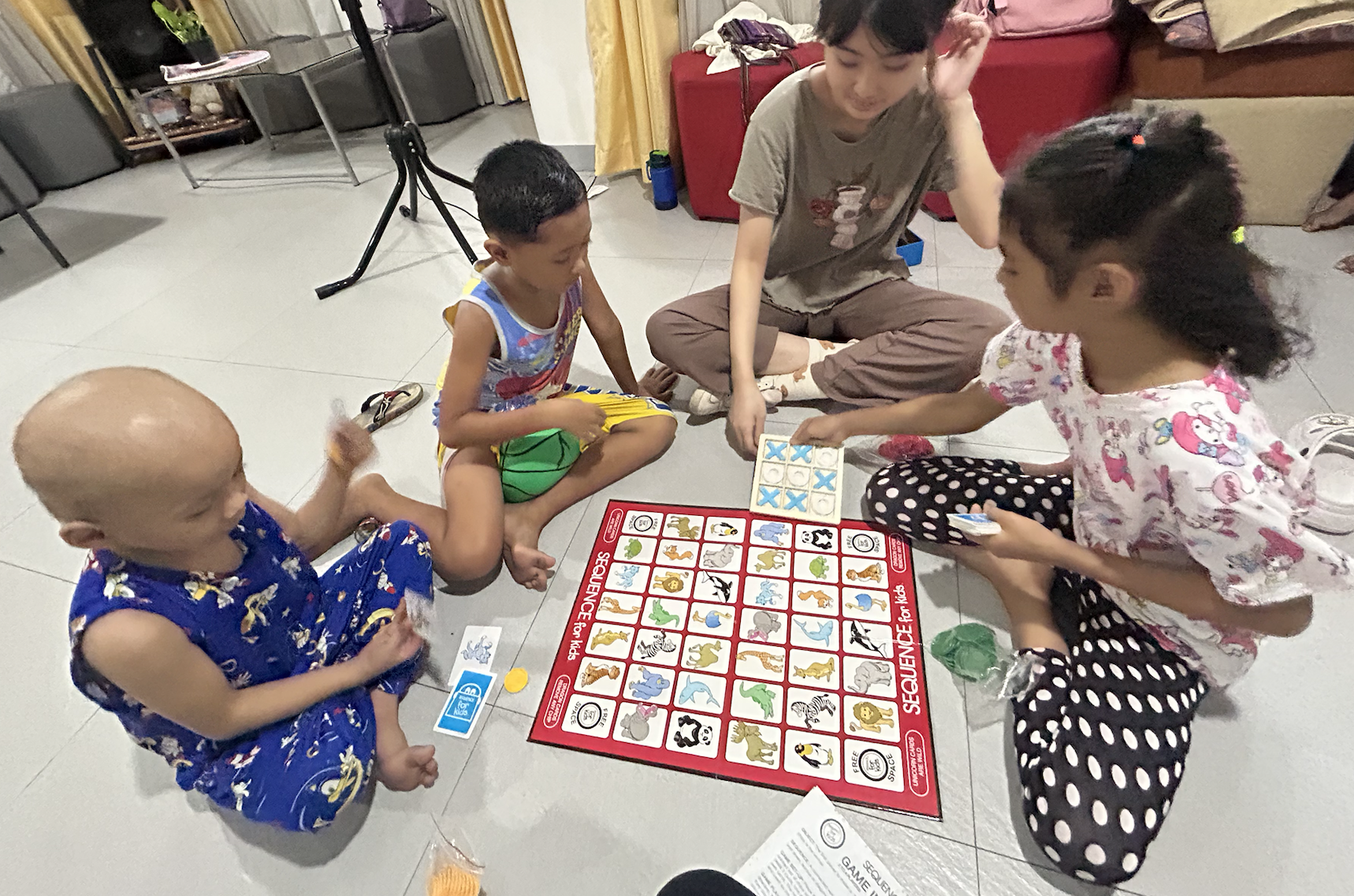 Children playing a board game with a Little Ark team member