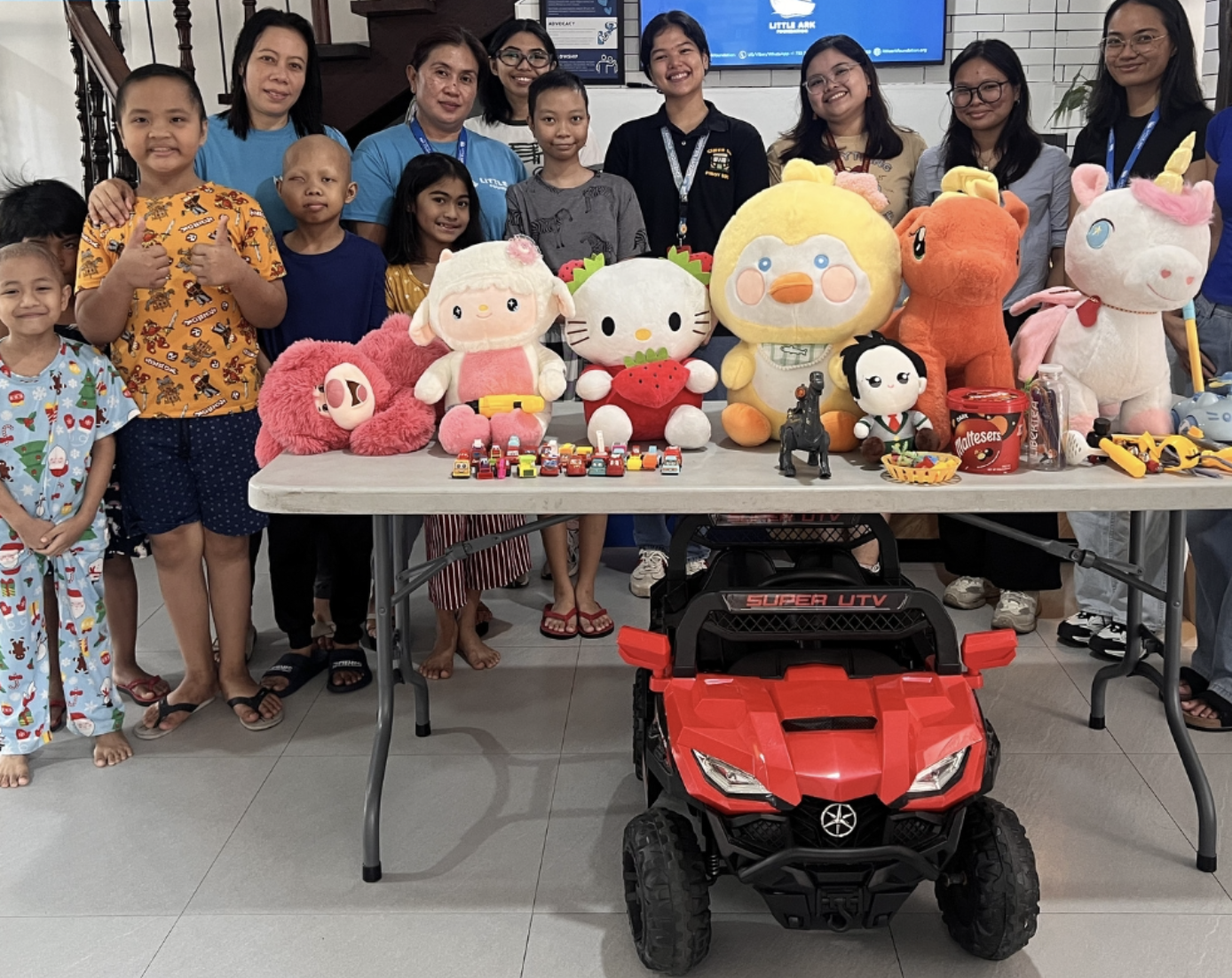 Children, caregivers, and Little Ark team members with donated toys and supplies